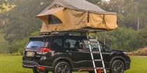 A tent mounted to the roof of a Subaru Forester