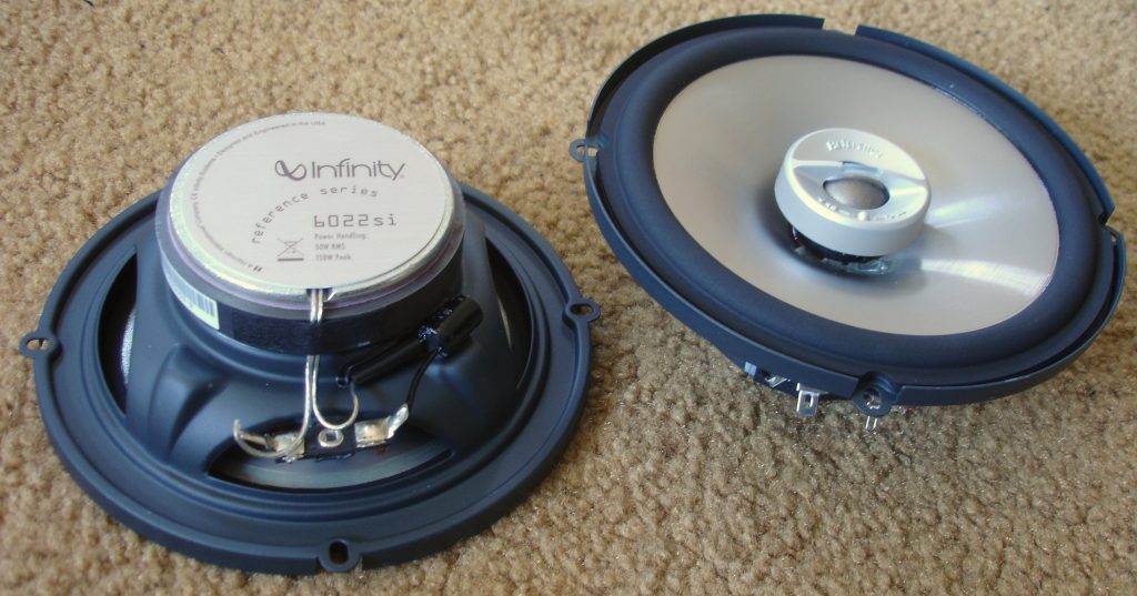 Two circular car speakers exposing their front and rears.