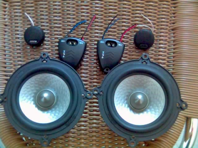 Black circular speakers and smaller circular tweeter kit with exposed wires. 