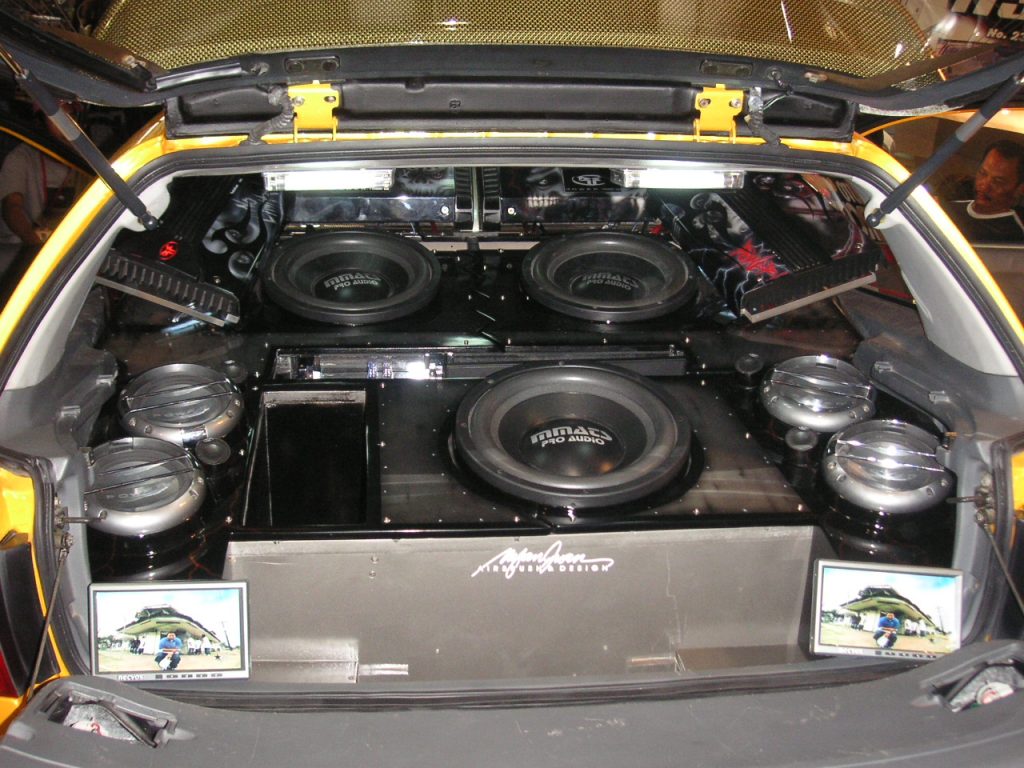 Trunk of car filled with assorted subwoofers