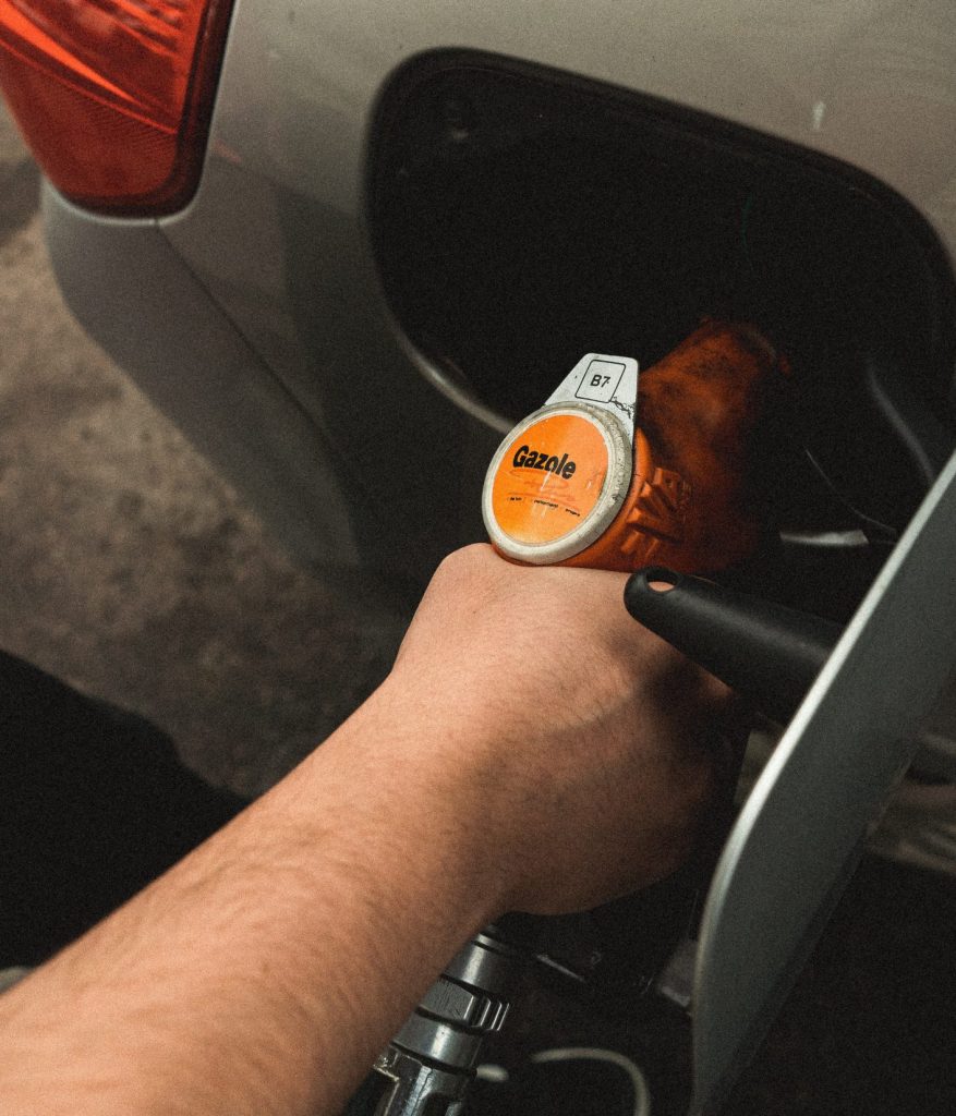 Handle of a gasoline pump pumping gas into car. 